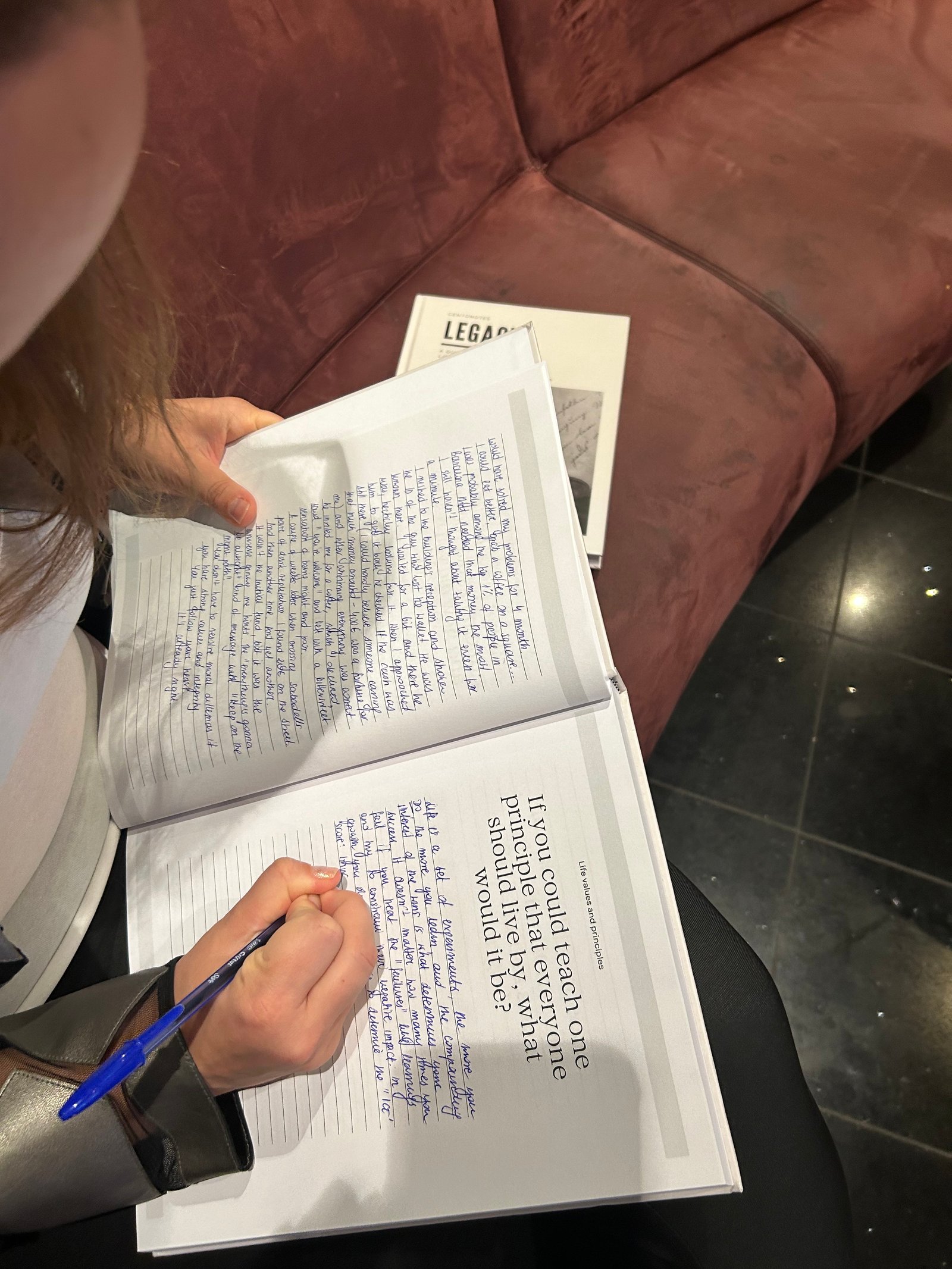 Person writing heartfelt answers in the Centonotes Legacy notebook